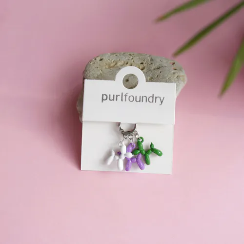 Purple, green and white knit stitch markers in the shape of balloon animals